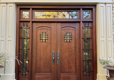 Stained wood double doors with a transom and iron-grille sidelights in Northbrook