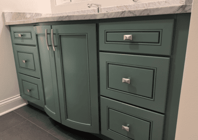 Bathroom vanity cabinet painted deep green with silver hardware in Morton Grove
