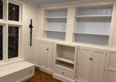 White painted built-in cabinets and shelves with a window seat in Northbrook