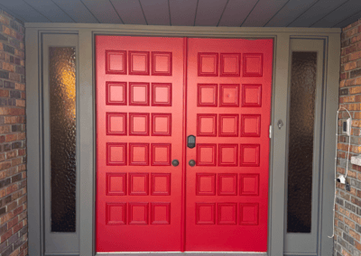 Red double entry doors with gray trim and tall sidelights in Northbrook