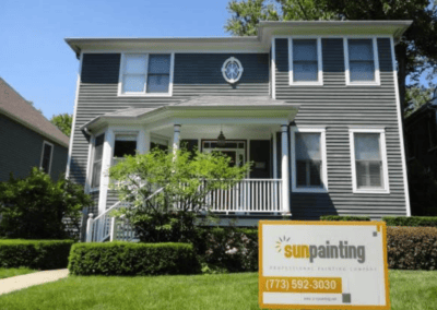 Two-story home with gray siding and white trim after exterior painting