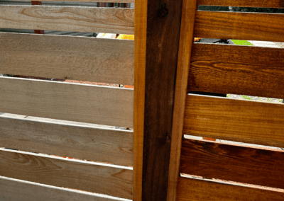 Cedar fence boards before and after staining, side by side, in Niles