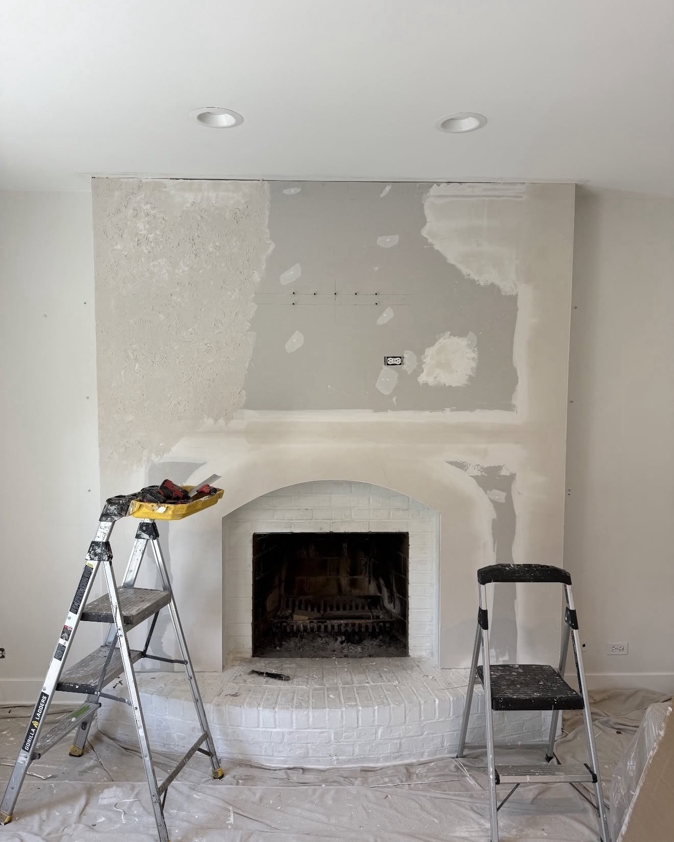 Fireplace feature wall mid-repair in Park Ridge IL, fresh drywall compound patches and open seams before skim coating by Sunpainting
