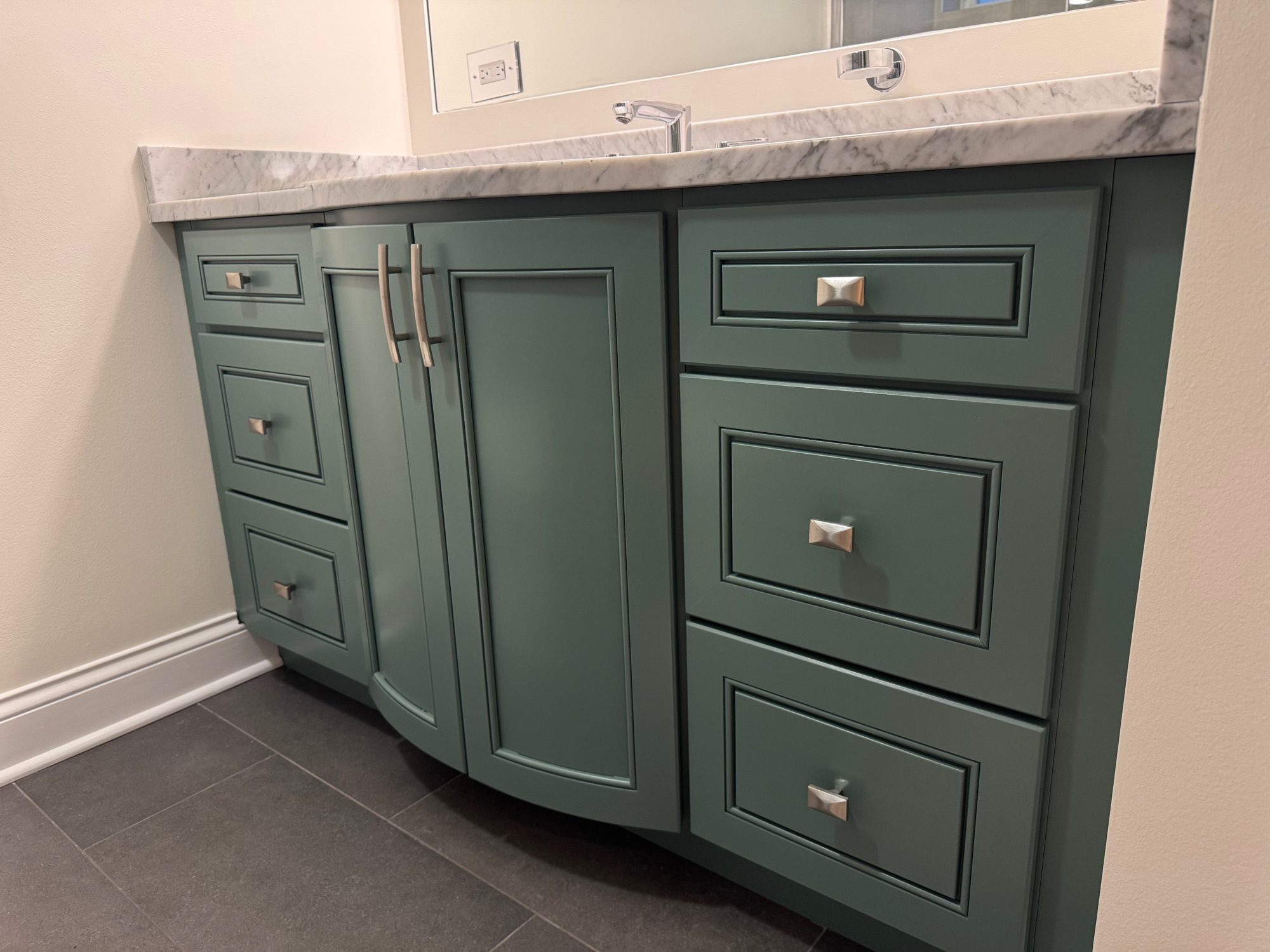 Bathroom vanity painted sage green by Sunpainting with marble countertop and silver hardware