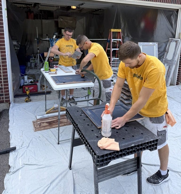 Sunpainting crew prepping cabinet doors on work tables