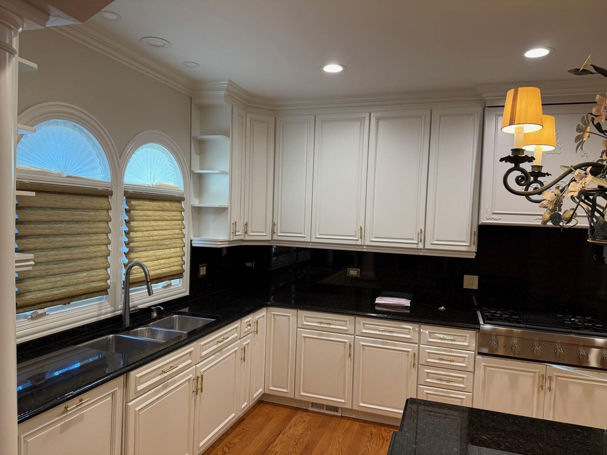 White painted kitchen cabinets with black granite counters and arched windows by Sunpainting White painted kitchen cabinets with black granite counters and arched windows by Sunpainting
